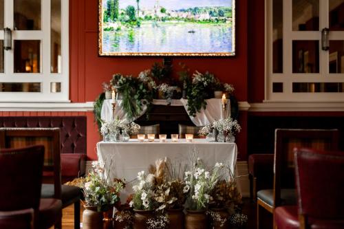 a table in a room with flowers and candles at The Drayton Court Hotel in London