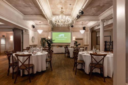 a conference room with tables and chairs and a screen at The Drayton Court Hotel in London