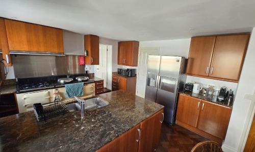 Una cocina con gabinetes de madera y un refrigerador de acero inoxidable. en Upper Northgate street, en Chester