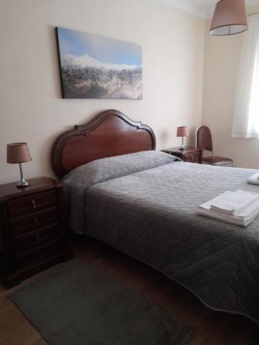 Un dormitorio con una cama grande y dos mesitas de noche. en Moradia Félix - Apartamento Félix, en Manteigas