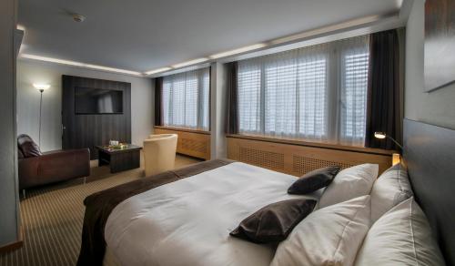 a hotel room with a large bed and a chair at Crowne Plaza Zürich by IHG in Zürich