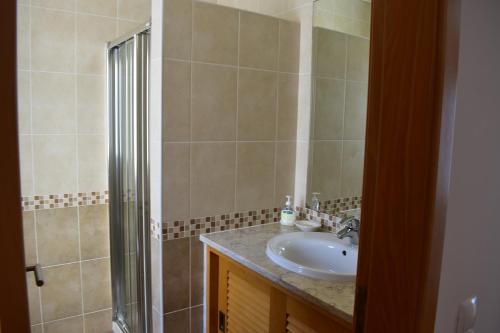 a bathroom with a sink and a shower at Esplendor beiramar refúgio na Praia del Rey B9 in Amoreira