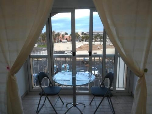 d'un balcon avec une table en verre et deux chaises. dans l'établissement Studio Port Soleil PS580 - 2 personnes, au Cap d'Agde