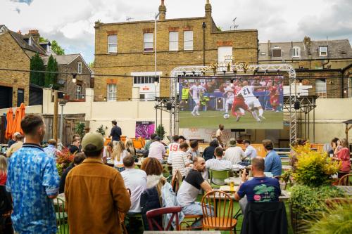 a crowd of people watching a game on a stage at The Drayton Court Hotel in London
