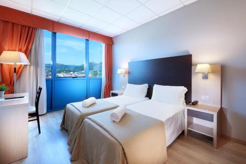 a hotel room with a bed and a large window at Tuscany Inn in Montecatini Terme