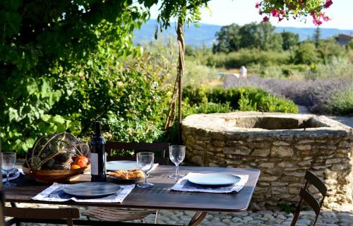 - une table en bois avec des verres à vin et un panier de nourriture dans l'établissement Bastidon Silvestre, à Saint-Saturnin-lès-Apt