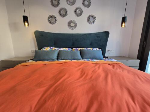 a bed with an orange blanket on top of it at Chalet del Faro in Cabo de Palos