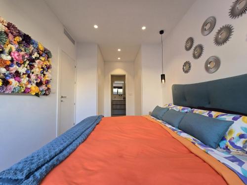 a bedroom with a large bed with an orange blanket at Chalet del Faro in Cabo de Palos