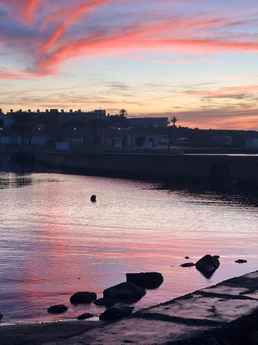 a sunset over a body of water with rocks at Chalet del Faro in Cabo de Palos