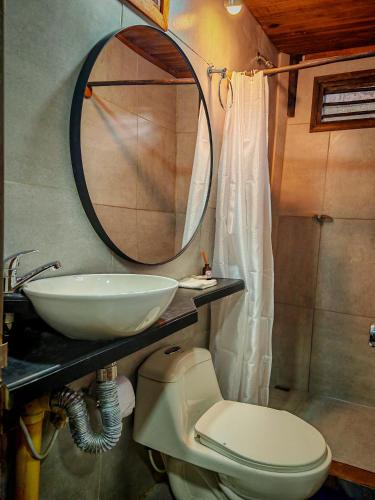 a bathroom with a sink and a toilet and a mirror at Casa Juntos by Villa Eden in Palomino