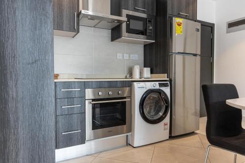 eine Küche mit Waschmaschine und Kühlschrank in der Unterkunft Imperial Suite in Accra
