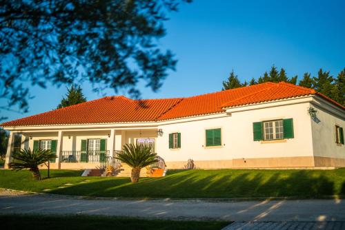 a large white house with an orange roof at Monte dos Rolas in Alcácer do Sal