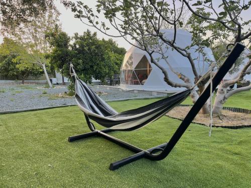a hammock sitting on the grass near a tree at Geometry Park in Ayios Theodhoros