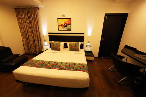 a hotel room with a large bed and a couch at Purple Brigade, Bangalore in Bengaluru