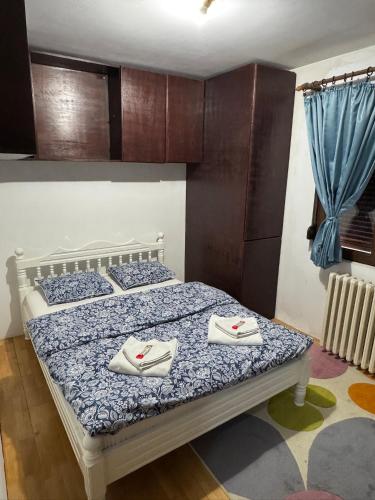 a bedroom with a bed with two towels on it at Vila Bojana in Gornji Milanovac