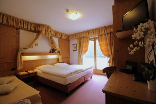 a hotel room with a bed and a window at Hotel Al Forte in Arabba