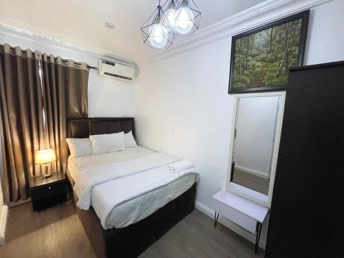 The Aire Flat في لاغوس: غرفة نوم صغيرة بها سرير ونافذة