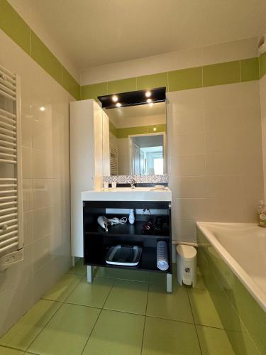 une salle de bain avec un lavabo, une baignoire et un miroir dans l'établissement Proche Lyon, Craponne centre Bel Apt T3 Terrasse, à Craponne