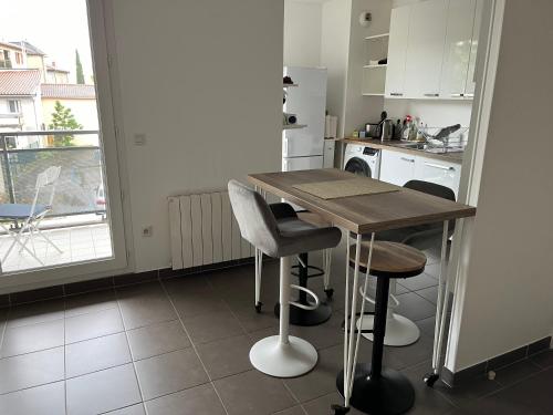 une cuisine avec une table en bois et deux tabourets dans l'établissement Proche Lyon, Craponne centre Bel Apt T3 Terrasse, à Craponne