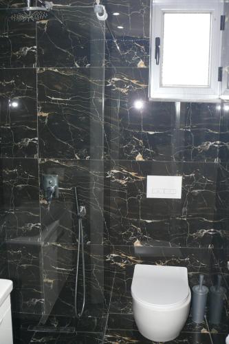 a bathroom with a black and gold marble wall at Hotel Erviliano in Borsh
