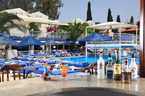 a pool with blue chairs and bottles on a table at Summer Garden Suites Beach Hotel in Bitez