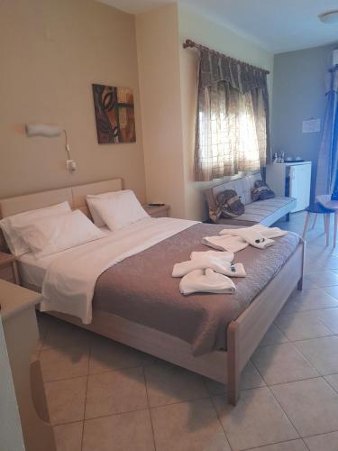 a bedroom with a large bed with towels on it at Delfini in Akhladherí