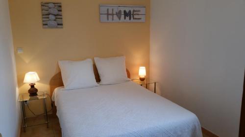 una camera da letto con un letto bianco con due lampade di Maison Alba Rossa 56 a Serra di Ferro