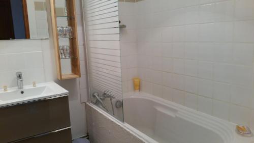 een badkamer met een wit bad en een wastafel bij Maison Alba Rossa 56 in Serra-di-Ferro
