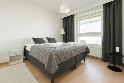 a white bedroom with a bed and a window at City Home Finland Panorama Suite - New Luxury Suite with Own SAUNA, One Bedroom, Spacious Balcony with City Views and Great Location next to Nokia Arena in Tampere