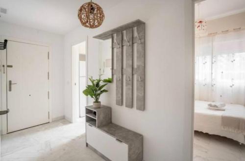 a white room with a potted plant on the wall at Apartamento El Mirador del Cantil in Isla Cristina