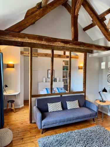 a living room with a blue couch in front of a bed at Wisteria in Fontainebleau