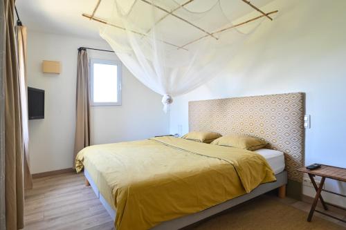 une chambre avec un lit avec un couvre-lit jaune dans l'établissement Maison Argelas Calme et Sérénité en famille, à La Croix-Valmer