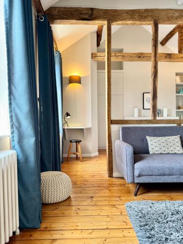 a living room with a blue chair and a table at Wisteria in Fontainebleau