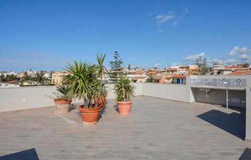 a row of potted plants sitting on a balcony at Lovely Apartment In Marina Di Modica in Marina di Modica