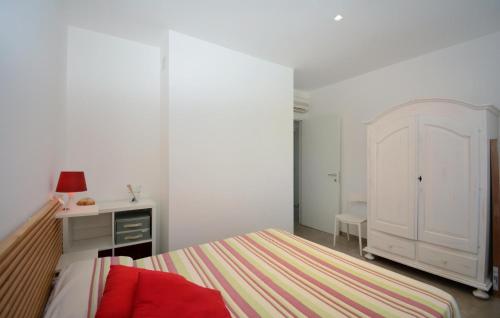 a white bedroom with a bed and a desk at Lovely Apartment In Marina Di Modica in Marina di Modica