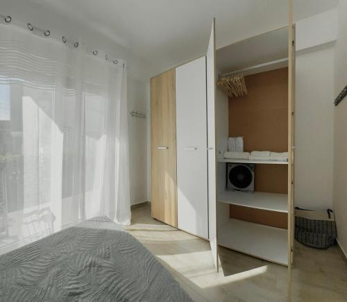 a bedroom with a bed and a closet with a microwave at Danai Apartment with pool Access in Ofrínion