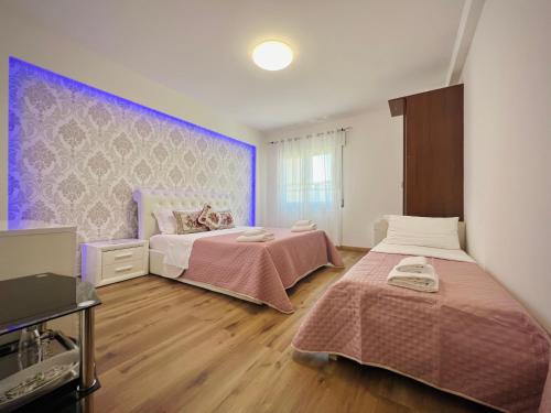 a bedroom with two beds with pink sheets at Blue Deluxe Venice in Venice