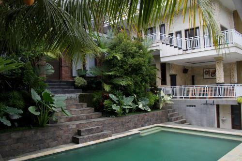a swimming pool in front of a building at Hanaka Riverside Ubud in Ubud