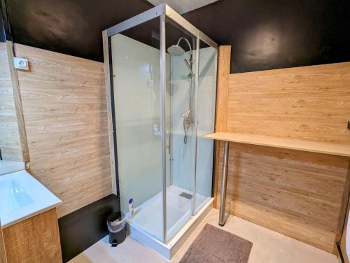 een glazen douche in een badkamer met een wastafel bij Appartement Chaleureux Gérardmer proche forêt in Gérardmer