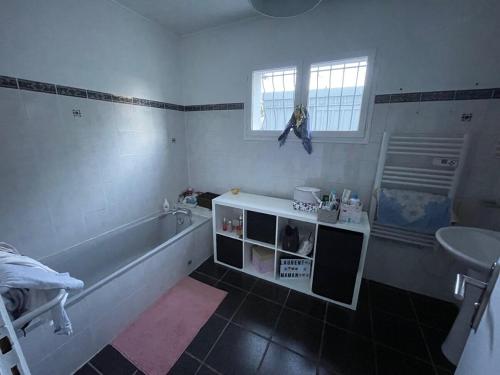 une salle de bain avec une baignoire et un lavabo dans l'établissement Maison landaise au calme entre Bordeaux et Atlantique, à Saint-Médard-en-Jalles
