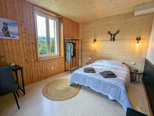 een slaapkamer met een bed in een houten kamer bij Appartement Chaleureux Gérardmer proche forêt in Gérardmer