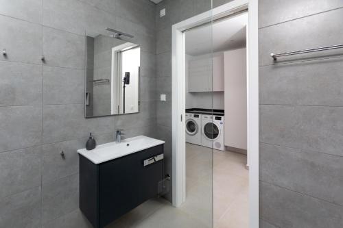 Un baño con lavabo y lavadora. en Casa Barbónica piscina privada, en Bairro do Lobo