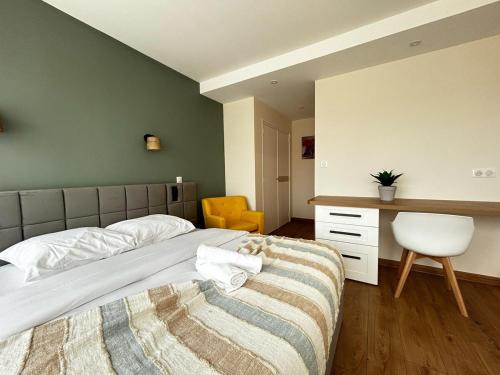 a bedroom with a bed and a desk and a chair at La Suite Chataîgner, chic et calme in Panazol