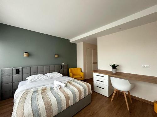 a bedroom with a bed and a desk and a chair at La Suite Chataîgner, chic et calme in Panazol
