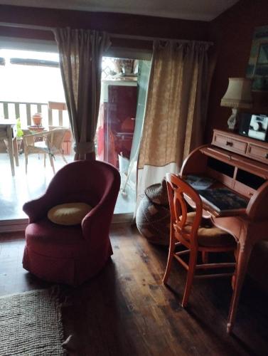 a living room with a chair and a table at Entre Terre et Ciel. in Saignon
