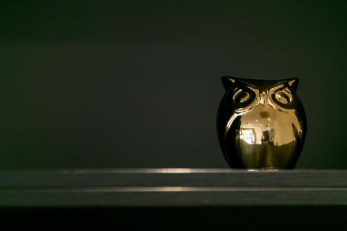 a gold owl vase sitting on a shelf at Ambra Hotel in Budapest