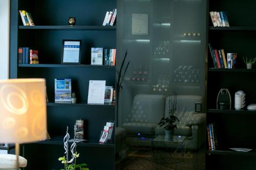 a living room with a book shelf with books at Ambra Hotel in Budapest