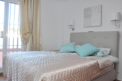 a bedroom with a bed with blue pillows on it at Casa Sandra in Arcos de la Frontera