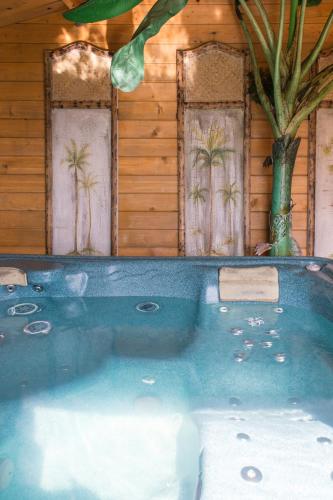 a hot tub in front of a house with palm trees at Ralph's Barn in Newport