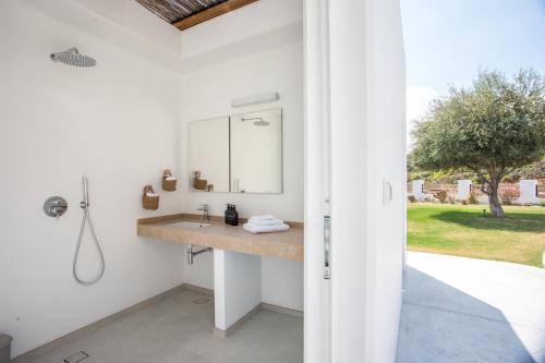 a bathroom with a sink and a mirror at Villa Elaia in Afantou